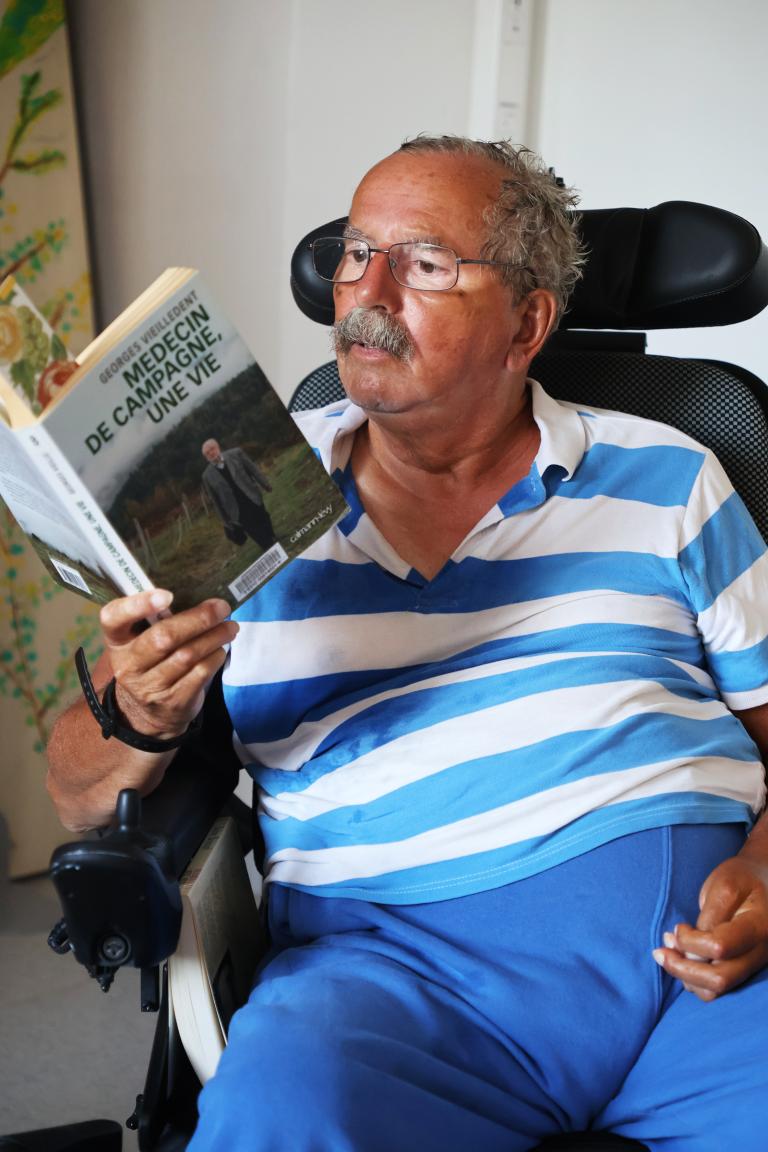 Un patient de l'EHPAD Les 5 Sens découvre l'un des livres offerts par la Médiathèque départementale du Puy-de-Dôme